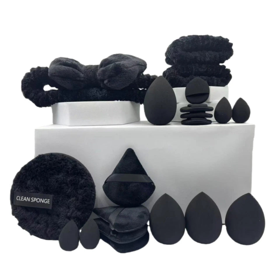 Set of black beauty tools including sponges and applicators on a white background