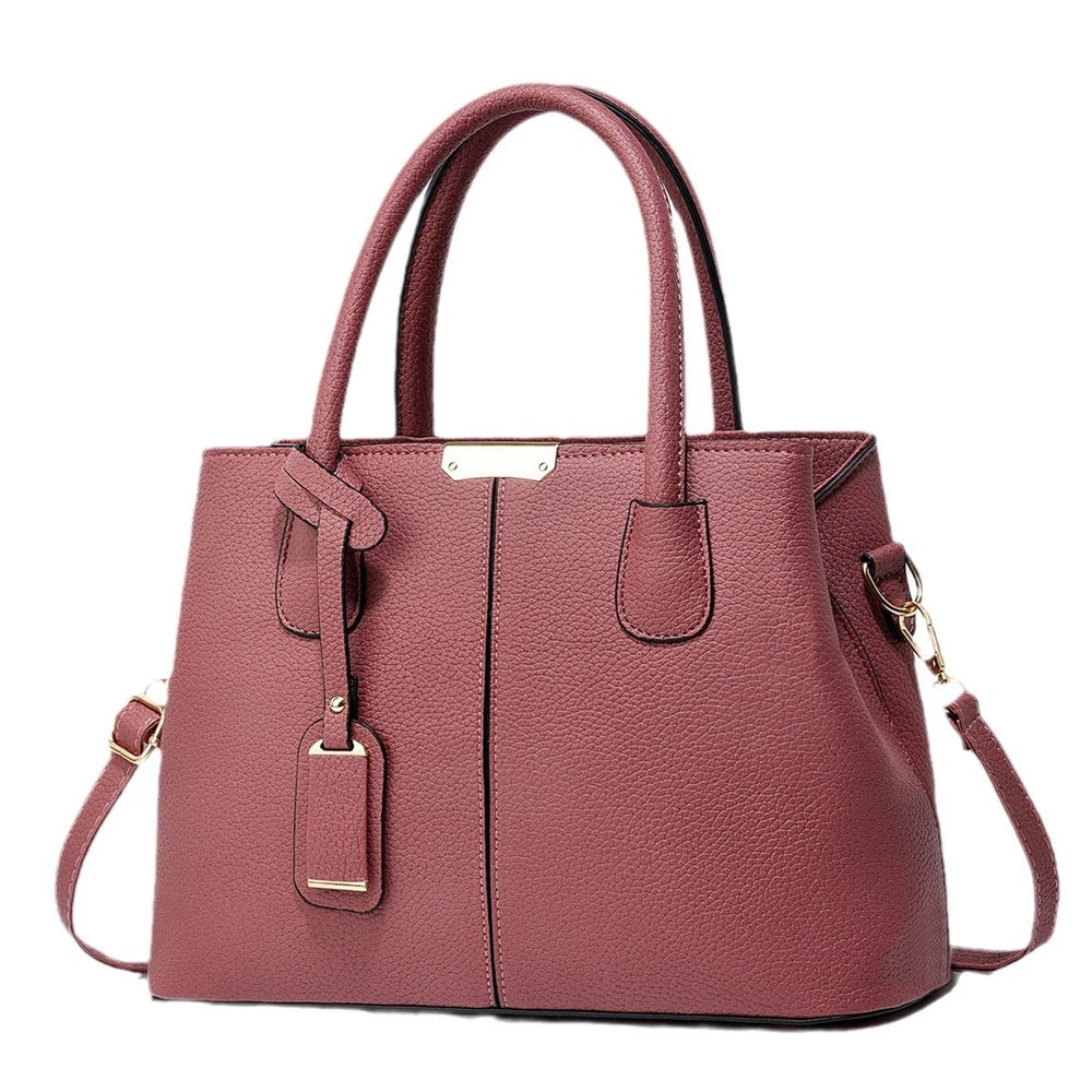 Pink handbag with gold accents on a white background