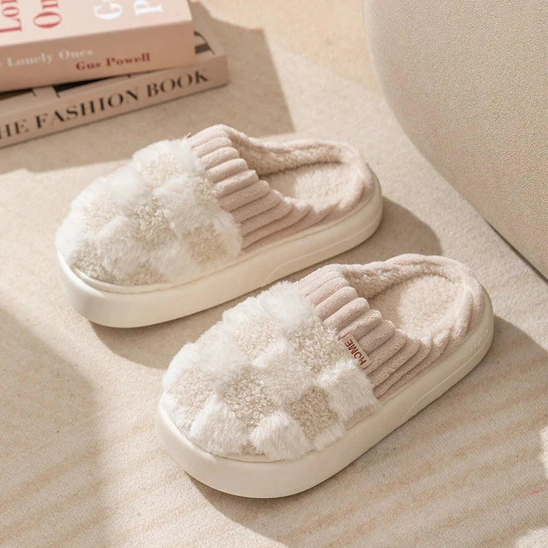 Pair of white slippers with fluffy texture on a light surface.