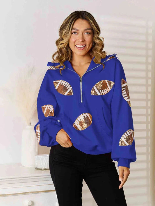 Model wearing a blue quarter-zip hoodie with football graphics on the front and sleeves.