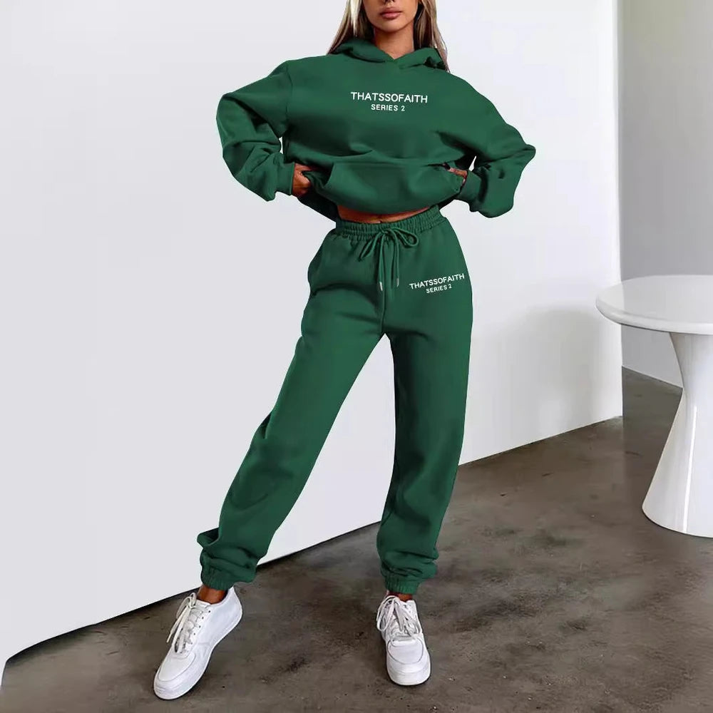 Person wearing a green tracksuit with text, standing against a white wall.
