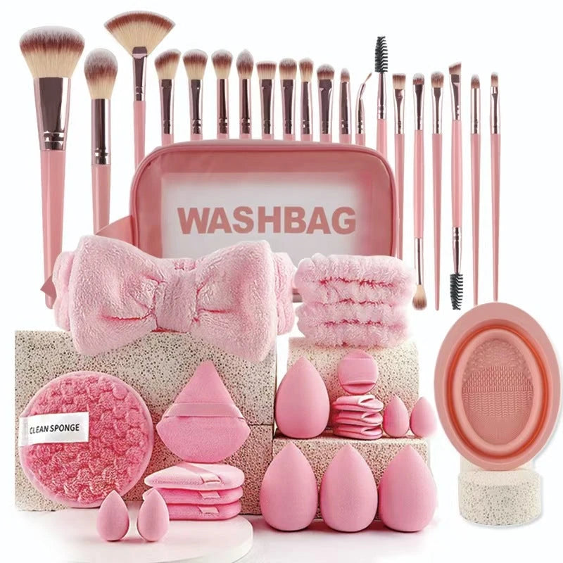 Pink makeup brushes, washbag, and accessories on a white background