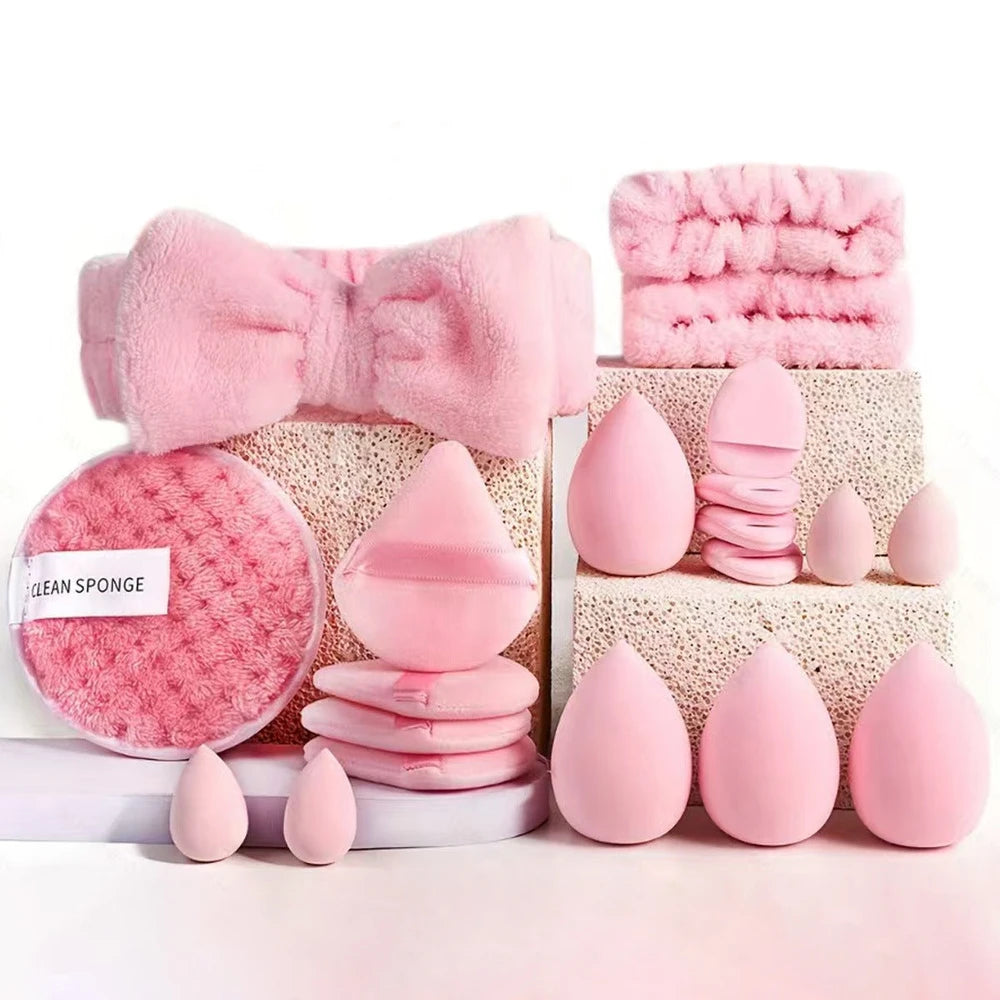 Set of pink makeup sponges and tools on a white background