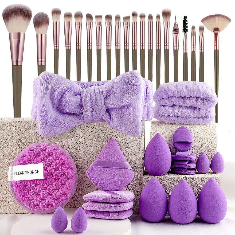 Makeup brushes, purple towels, and beauty sponges on a white background