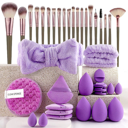 Makeup brushes, purple towels, and beauty sponges on a white background