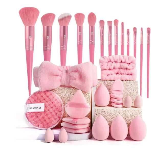 Set of pink makeup brushes and accessories on a white background