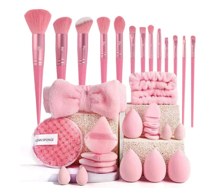 Set of pink makeup brushes and accessories on a white background