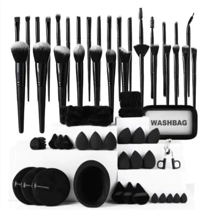Set of black makeup brushes and accessories with a washbag on a white background