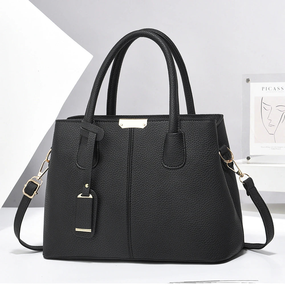 Black handbag with gold accents on a white background