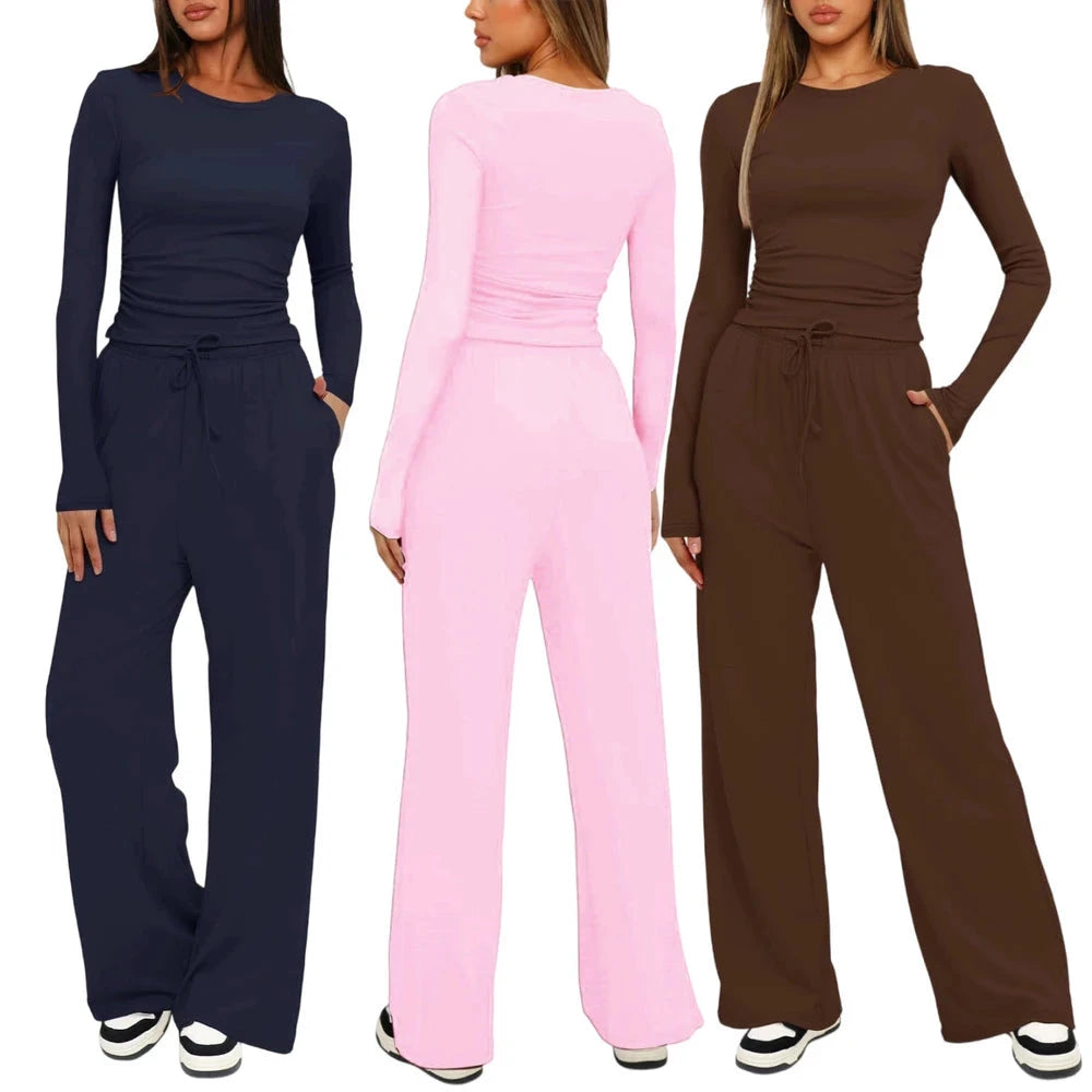 Three women modeling matching long-sleeve jumpsuits in navy blue, light pink, and brown, shown against a plain white background.