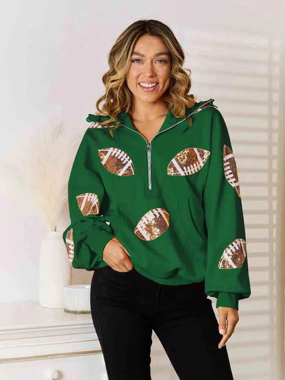 Model wearing a green quarter-zip hoodie with football graphics on the front and sleeves.