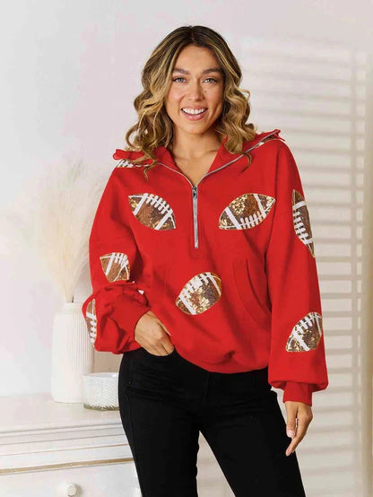 Model wearing a red quarter-zip hoodie with football graphics on the front and sleeves.