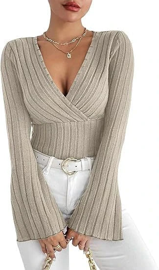 Model wearing a Beige ribbed wrap-style V-neck top with long bell sleeves, styled with white pants.