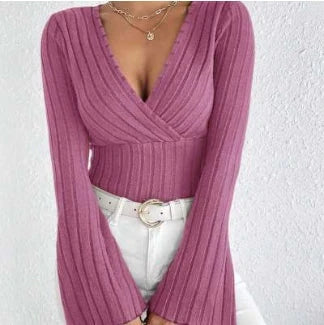 Pink ribbed sweater worn by a person on a white background