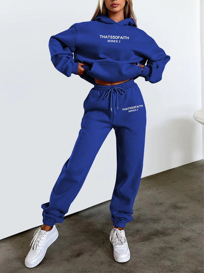 Person wearing a blue tracksuit with text on it, standing against a white background.
