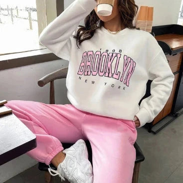  White Brooklyn New York graphic sweatshirt paired with pink joggers.