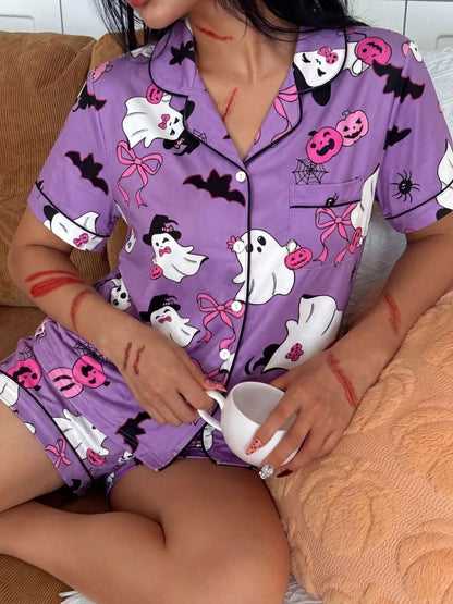 A woman wearing a purple short-sleeve pajama set with a Halloween print of ghosts, pumpkins, bats, and spiders, holding a white mug while sitting on a couch.