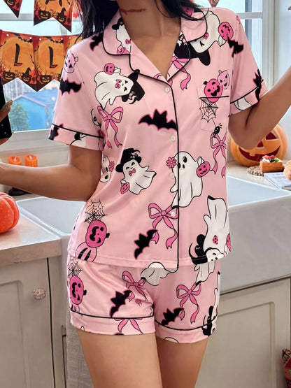 A woman wearing a pink short-sleeve pajama set with a Halloween print featuring ghosts, bats, pumpkins,  photographed in a kitchen setting.