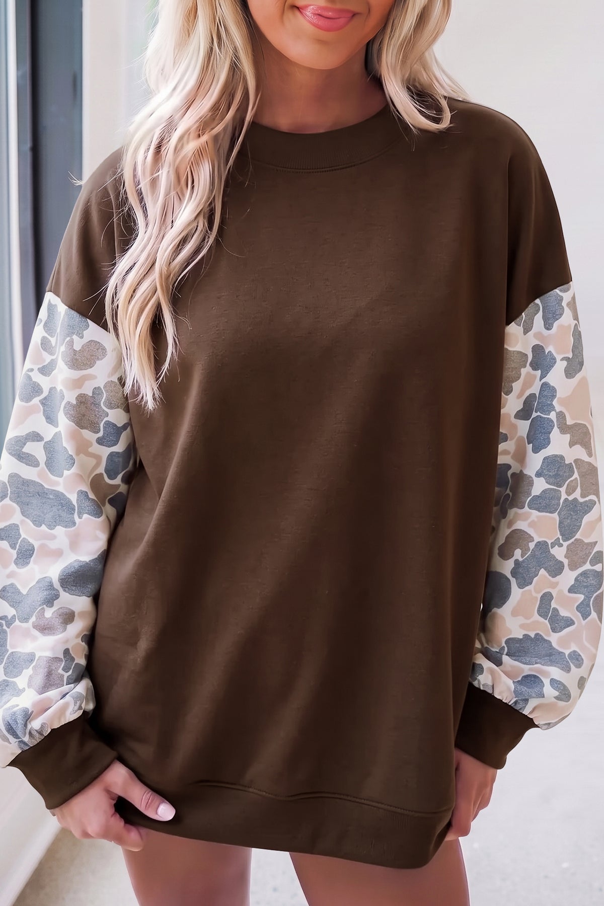 Coffee brown crewneck sweatshirt with camouflage print long sleeves and ribbed cuffs.